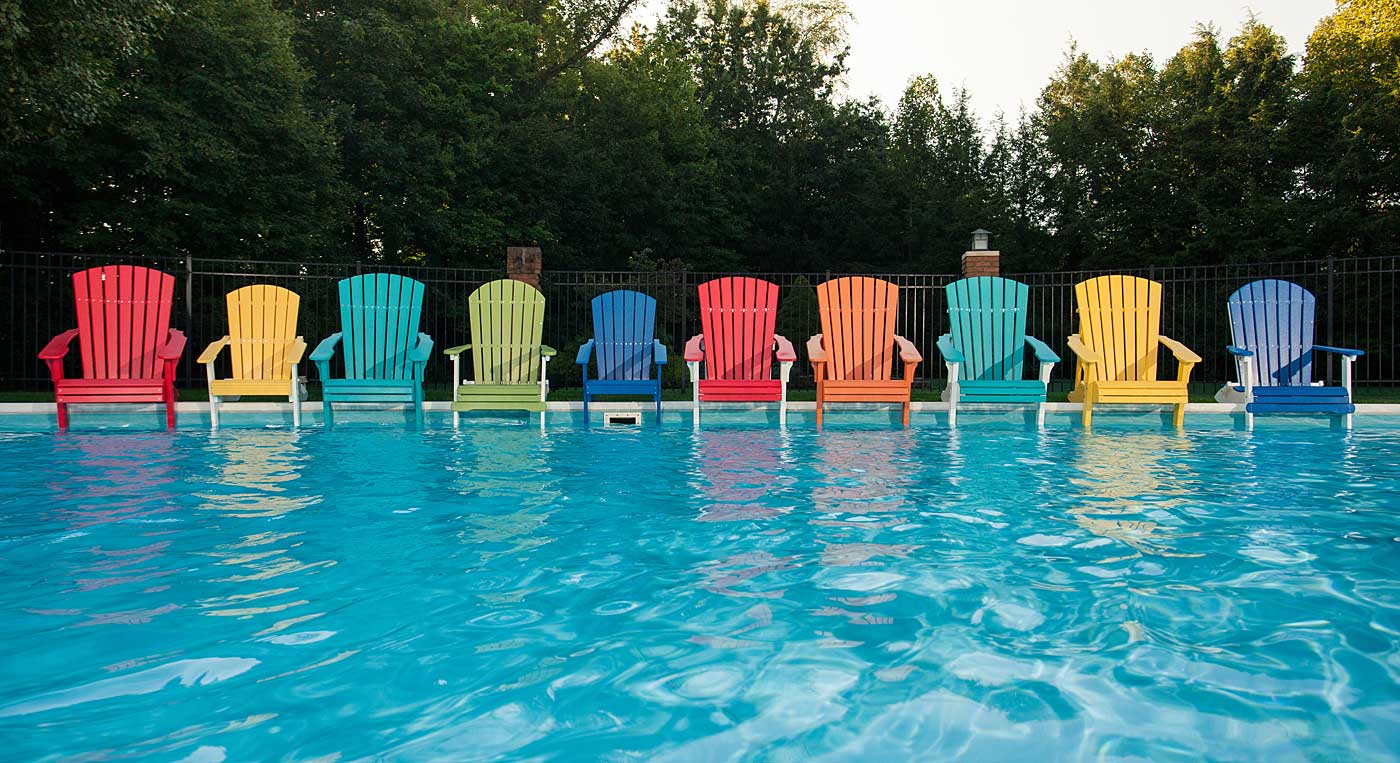 LuxCraft photo of Adirondack chairs beside a swimming pool